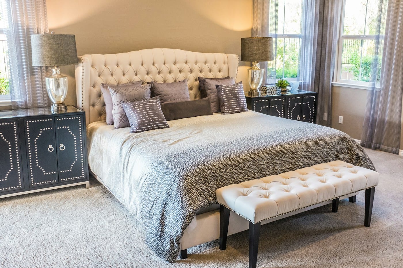 A guest suite with a tufted cream headboard